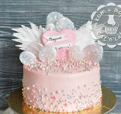 Розовый торт с леденцами и перьями